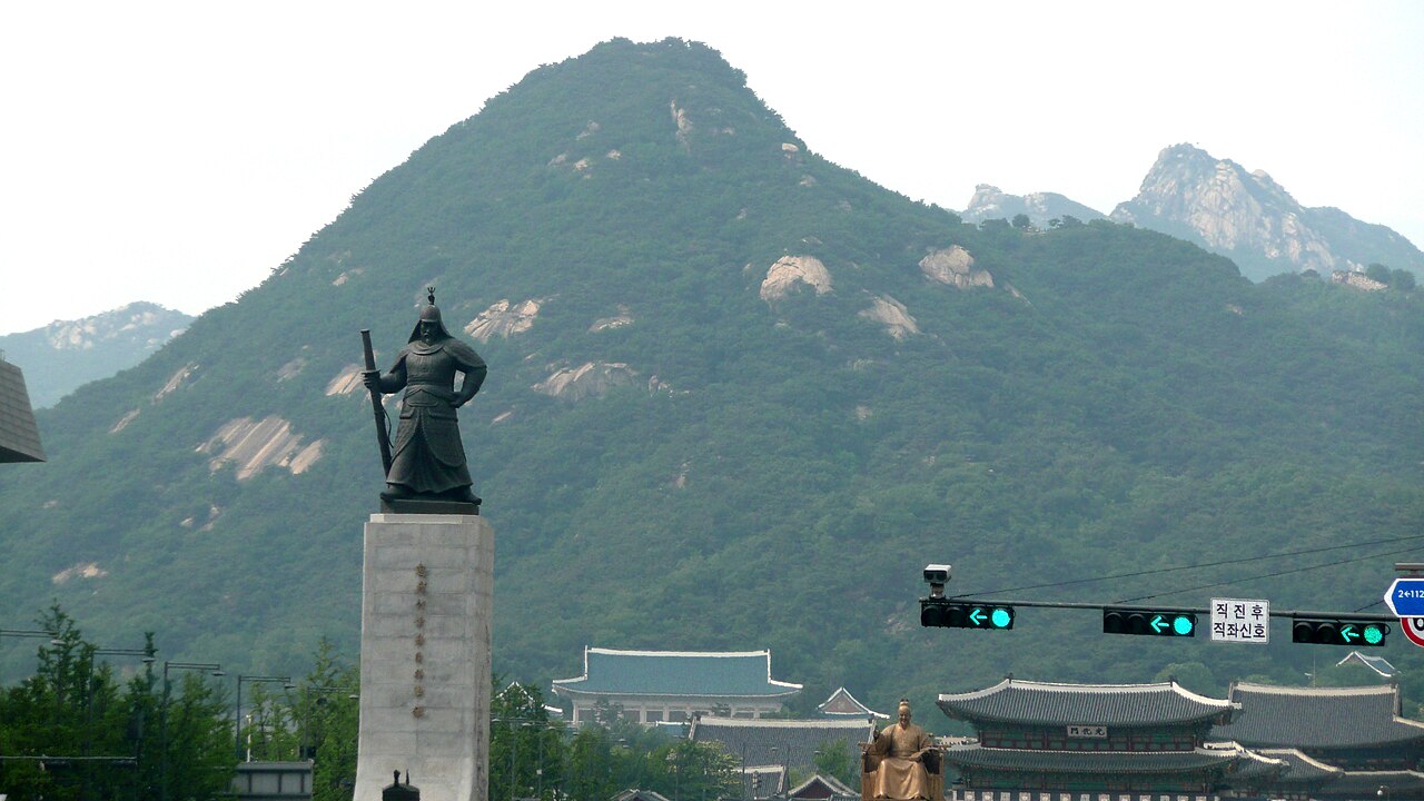 서울 광화문광장에 세워진 이순신 장군 동상, 뒤로 북한산이 보인다